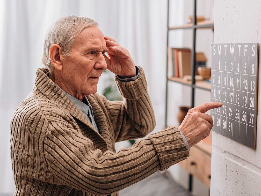 Homem idoso consultando um calendário para se orientar