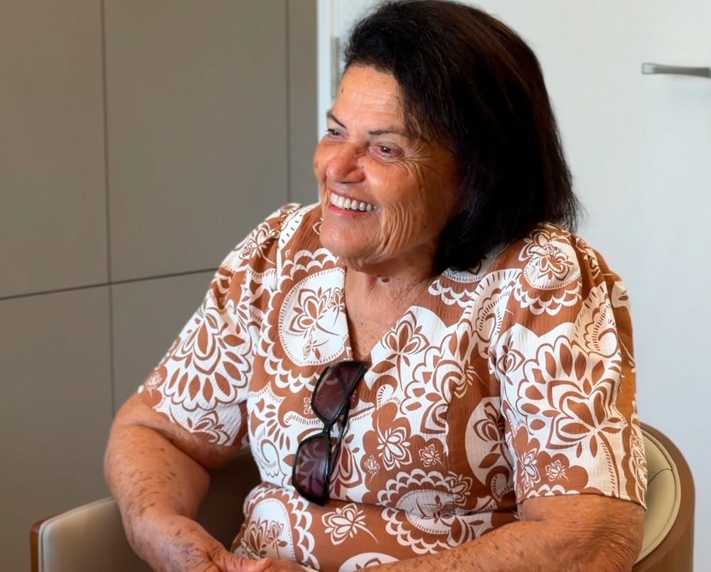 Paciente idosa sorrindo durante uma conversa no consultório